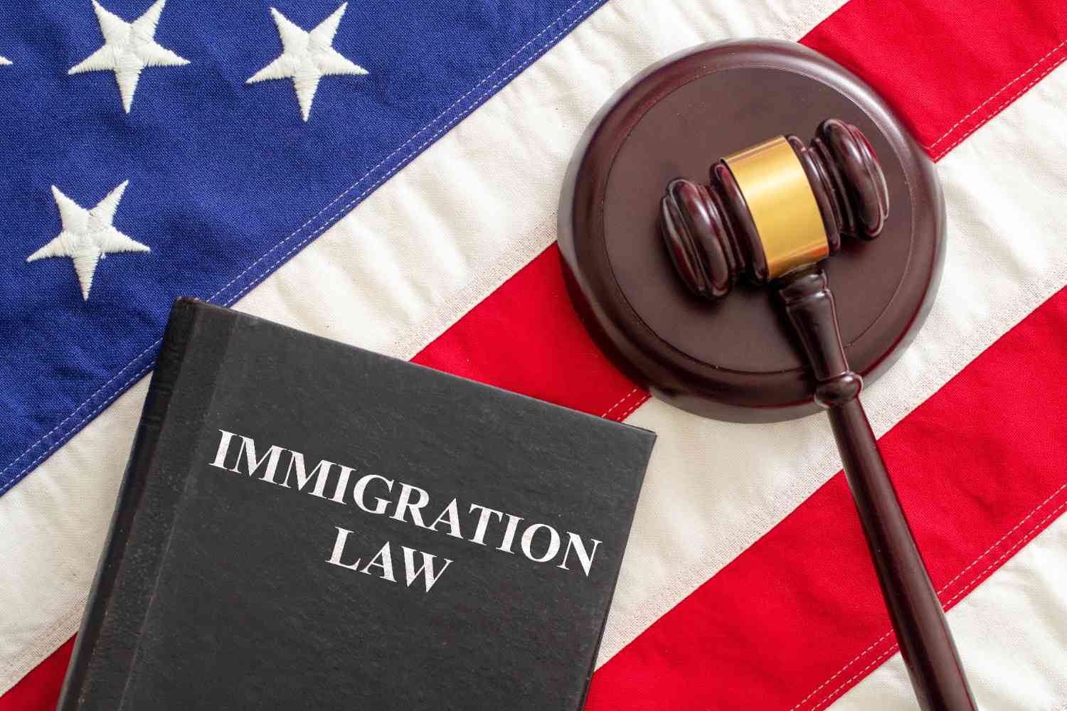 Immigration law book and judge gavel on American flag representing U.S. immigration legal aid and attorney services