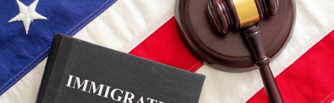 Immigration law book and judge gavel on American flag representing U.S. immigration legal aid and attorney services