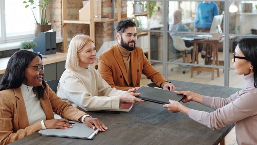 Immigration legal aid consultation with diverse attorneys and client reviewing documents in a modern legal office.
